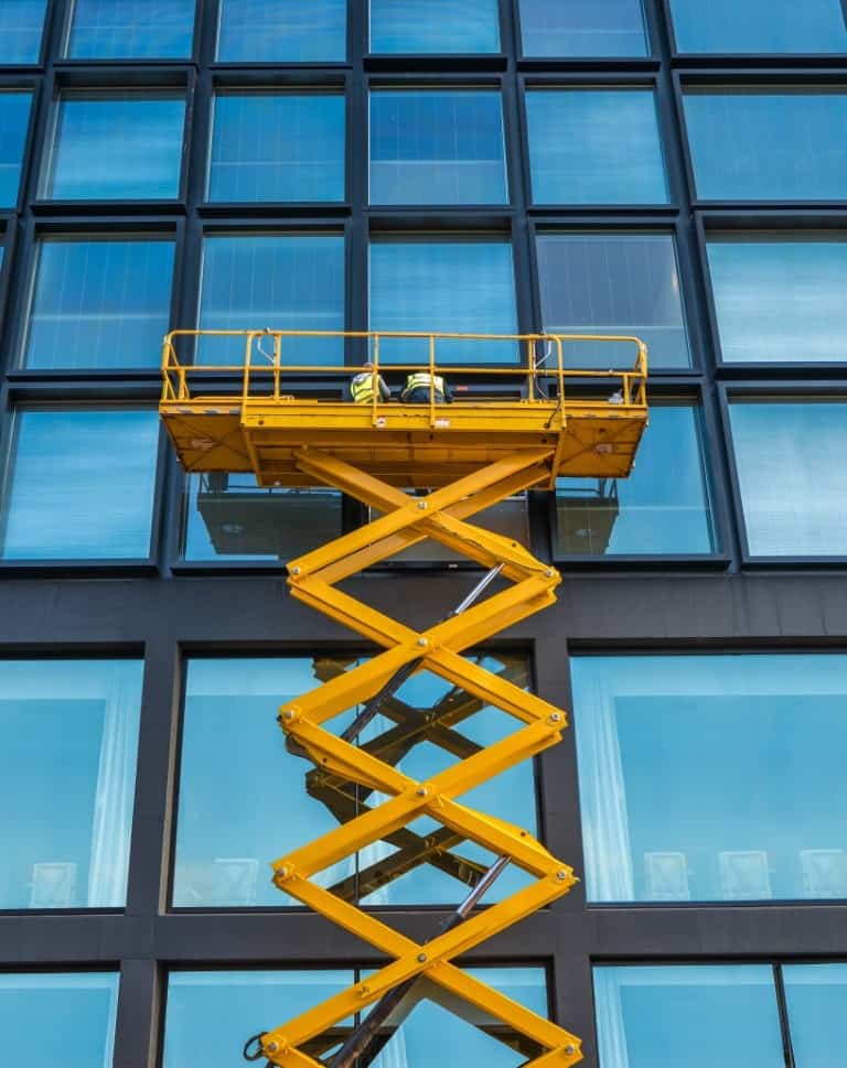 Workers On A Scissor Lift Cleaning Windows On A Financial Building Downtown